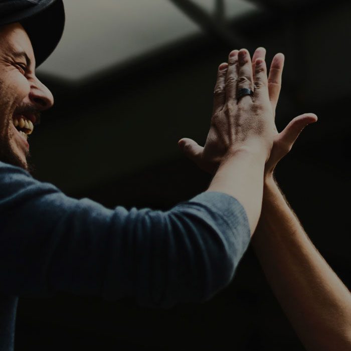 David Aaron high-fiving with hands another man